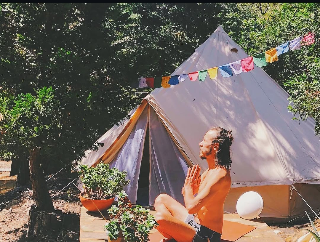 Meditation by a bell tent with prayer flags